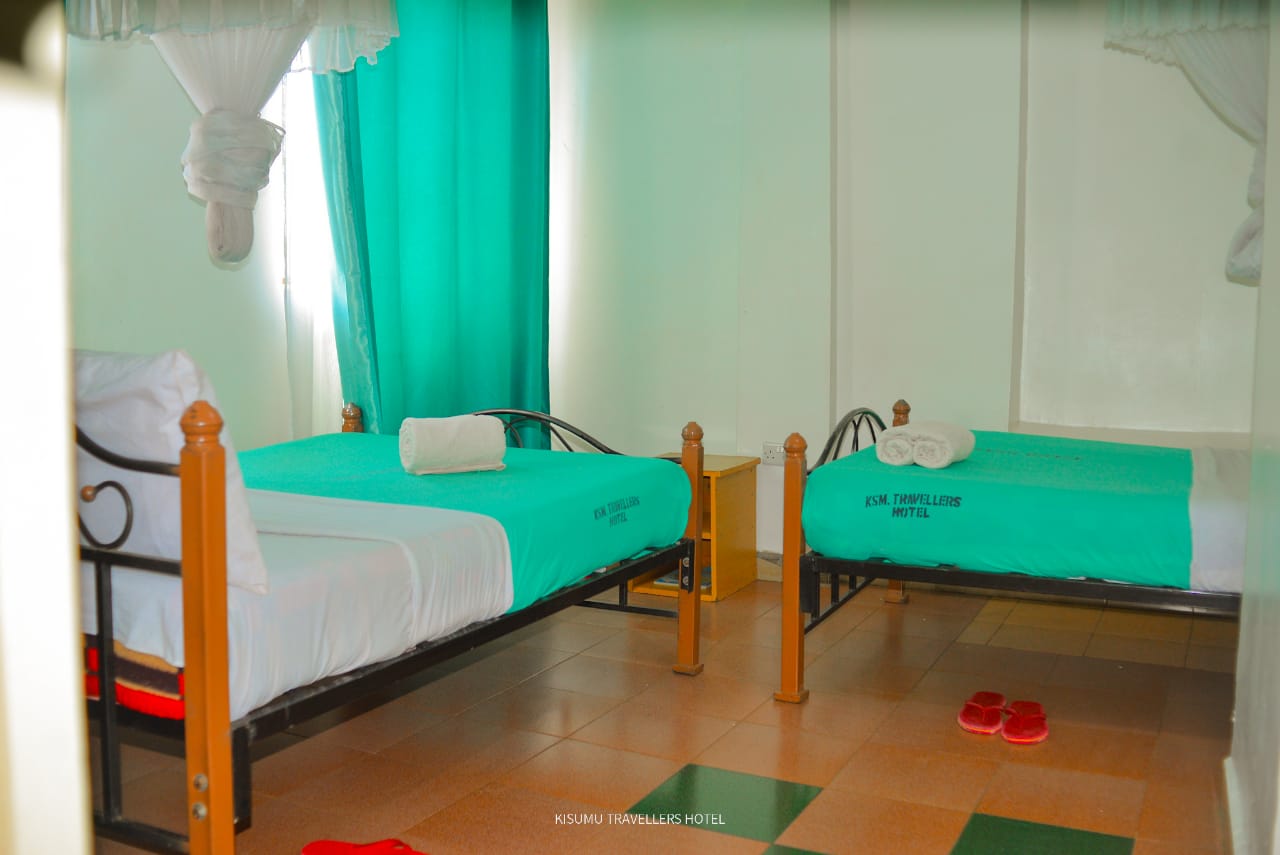 Twin room with two separate beds, turquoise bedding and mosquito nets